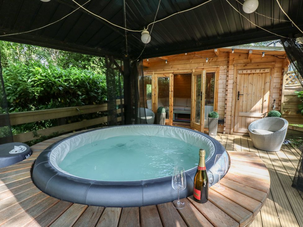 An outdoor seating area with a hot tub and champagne at Glebe House, Dalton-le-Dale near Murton, County Durham