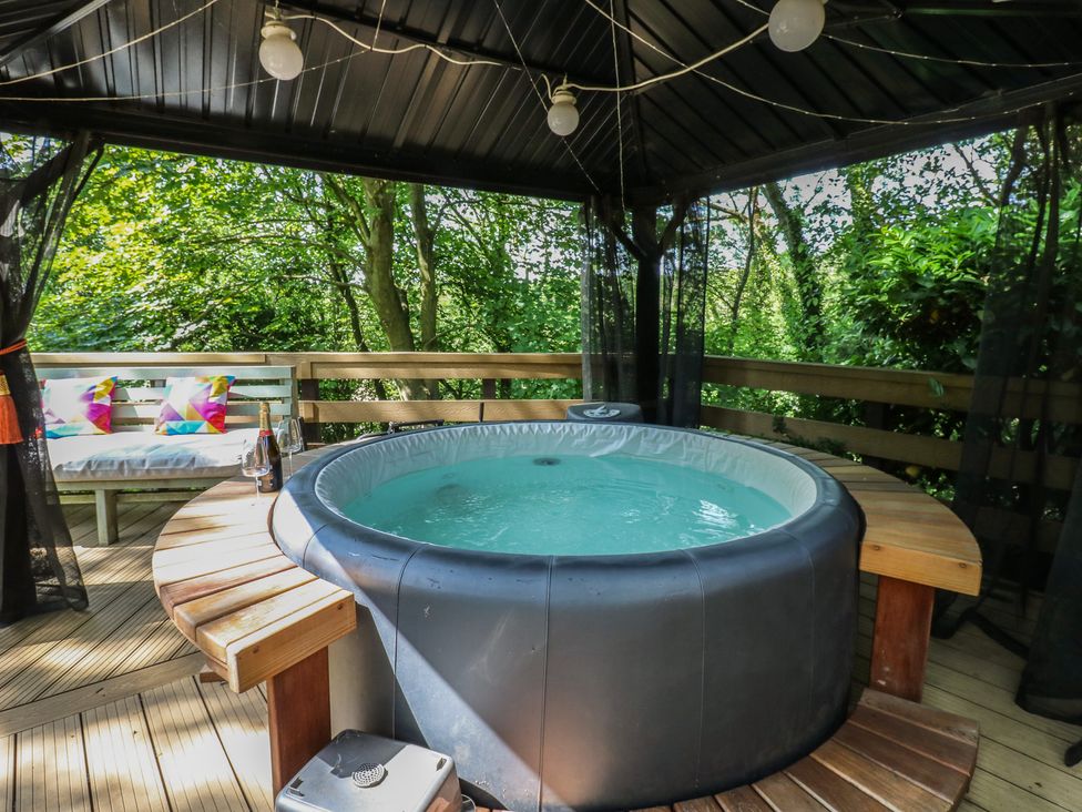 A hot tub with a wooden deck and seating area at Glebe House, Dalton-le-Dale near Murton, County Durham
