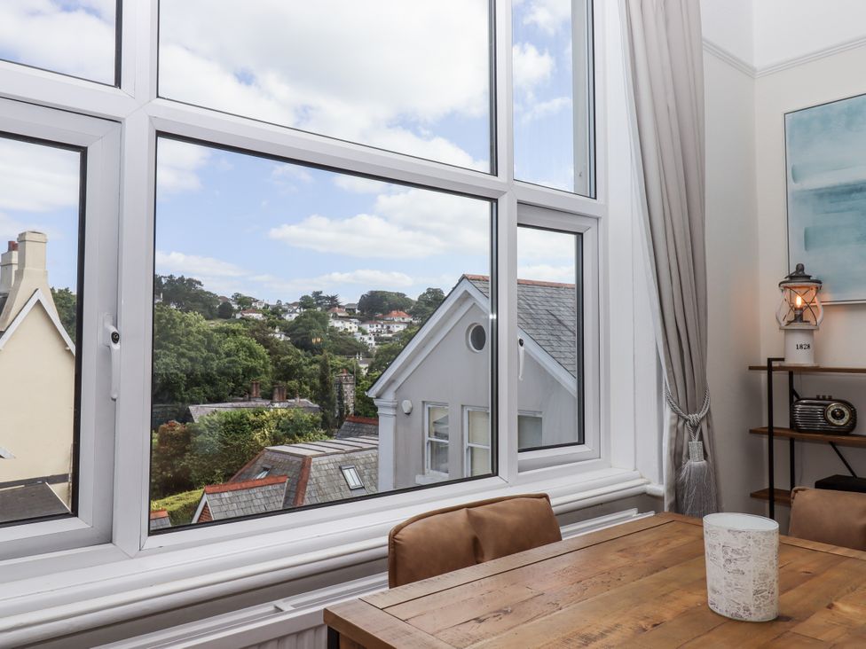 A dining room with a view of buildings and trees at Kinbrae Apartment in Torquay