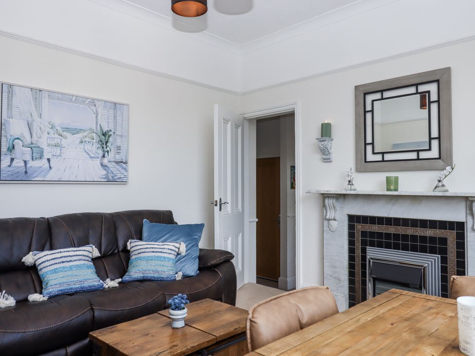 A living room with a sofa and painting at Kinbrae Apartment in Torquay