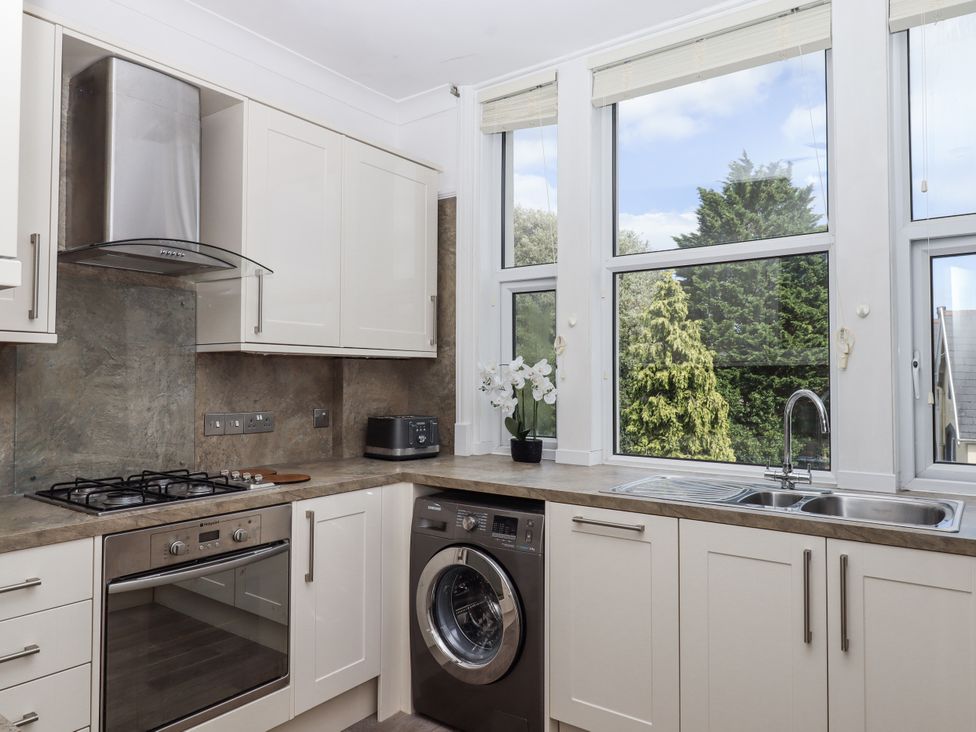 A kitchen with appliances and windows at Kinbrae Apartment in Torquay