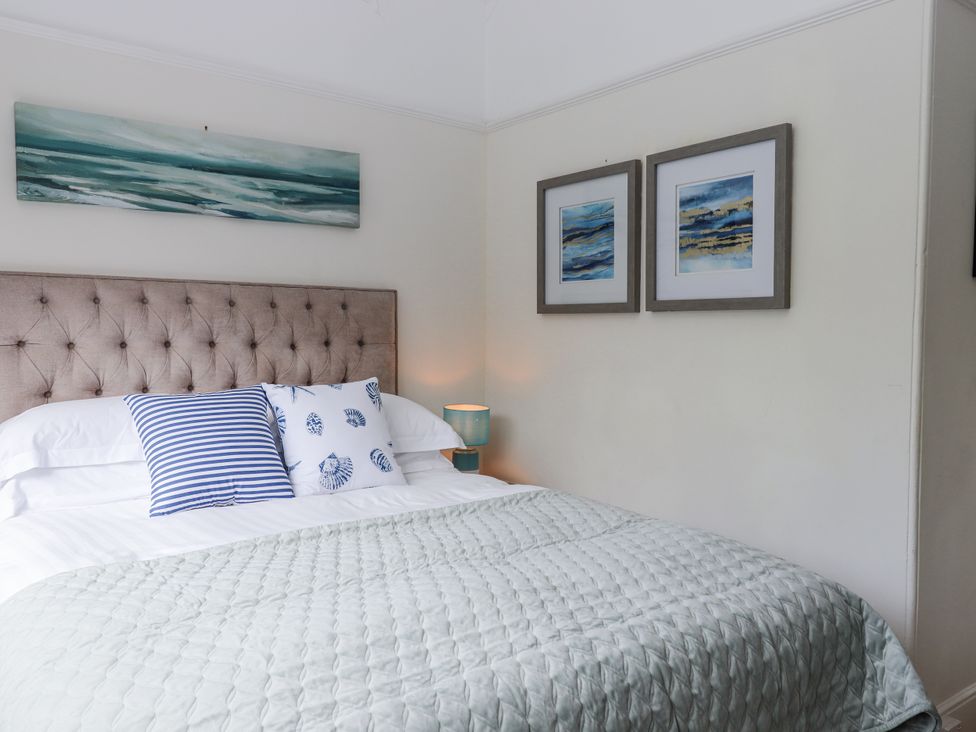 A bedroom with a bed and decorative items at Kinbrae Apartment in Torquay
