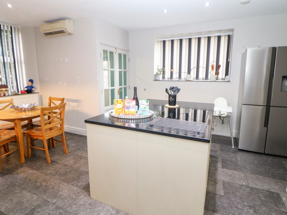 A kitchen with a table and chairs and kitchen island at The Old Post Office in Wirksworth