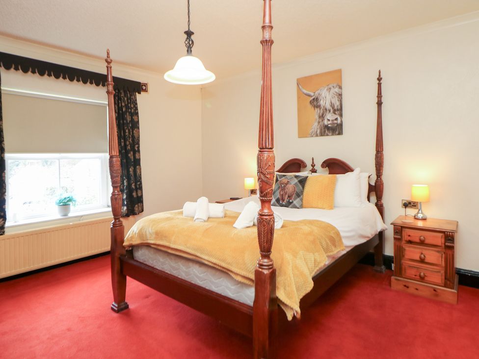 A bedroom with a four-poster bed and window at The Old Post Office Wirksworth