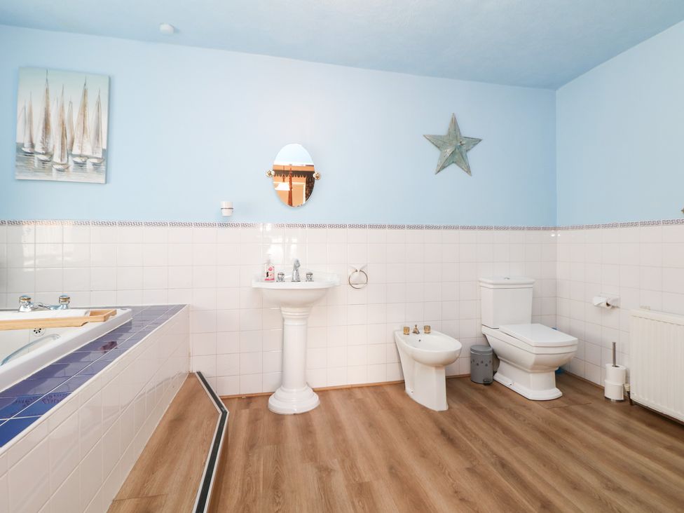 A bathroom with a bathtub, washbasin, and toilet at The Old Post Office in Wirksworth