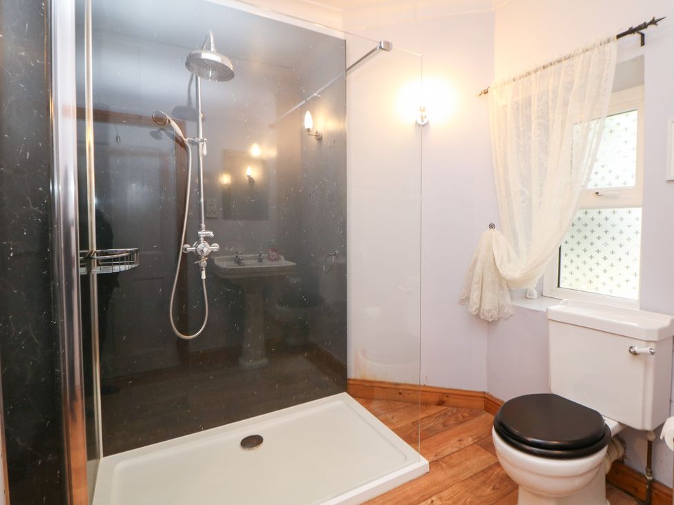 A bathroom with a shower, toilet, and sink at The Old Post Office Wirksworth