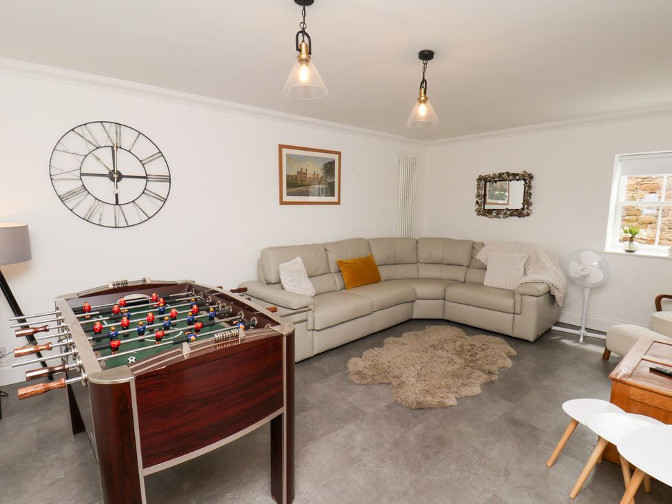 A living room with a foosball table and sofa at Fell Briggs Cottage in Marske-By-The-Sea