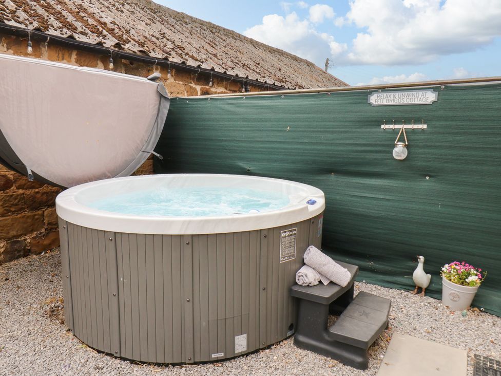 A hot tub with towels and a step stool at Fell Briggs Cottage in Marske-By-The-Sea