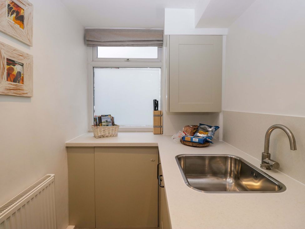 A kitchen with a sink and cabinets at 1 Tower House in Cartmel