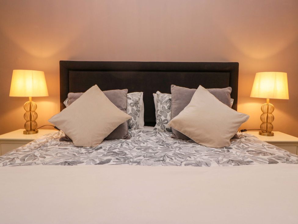 A bedroom with a bed and bedside lamps at 1 Tower House in Cartmel