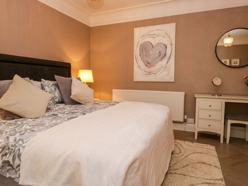 A bedroom with a bed, desk and mirror at 1 Tower House in Cartmel