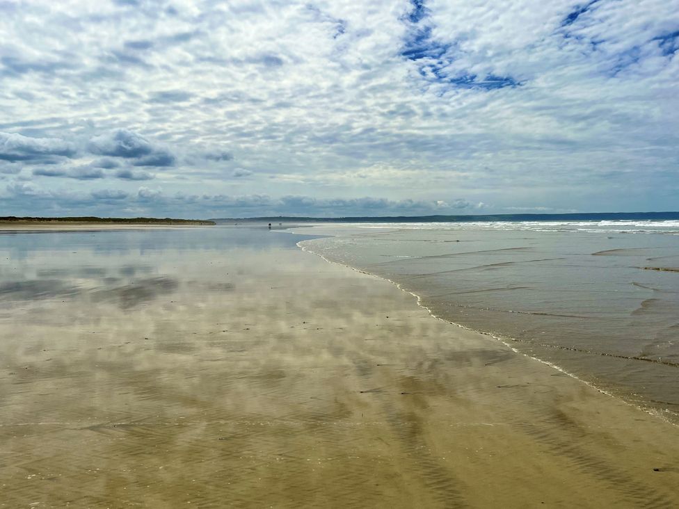 A beach with sand and water at Apple Barn South Molton