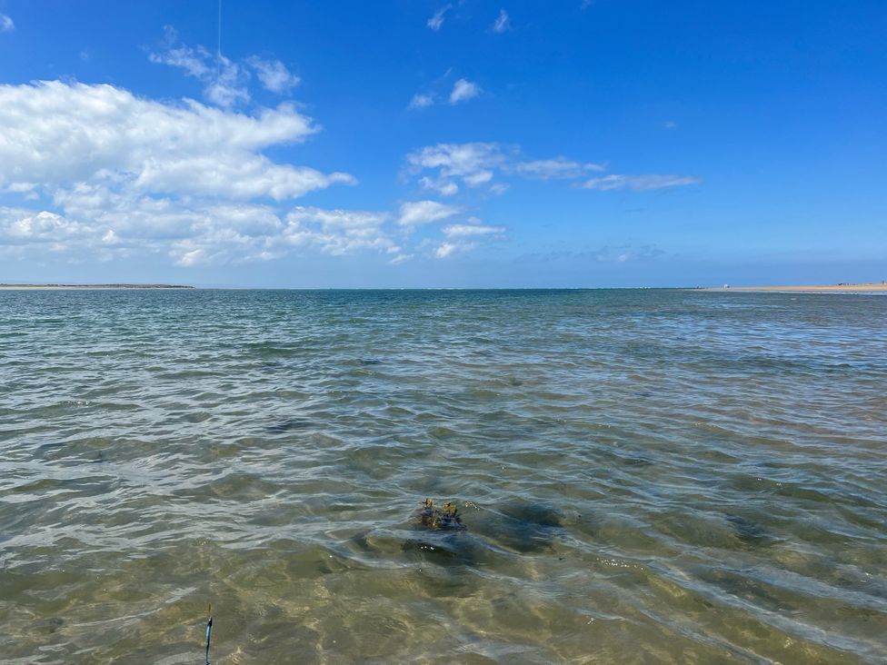 A view of water and sand under a clear sky at Hazel Barn in North Molton