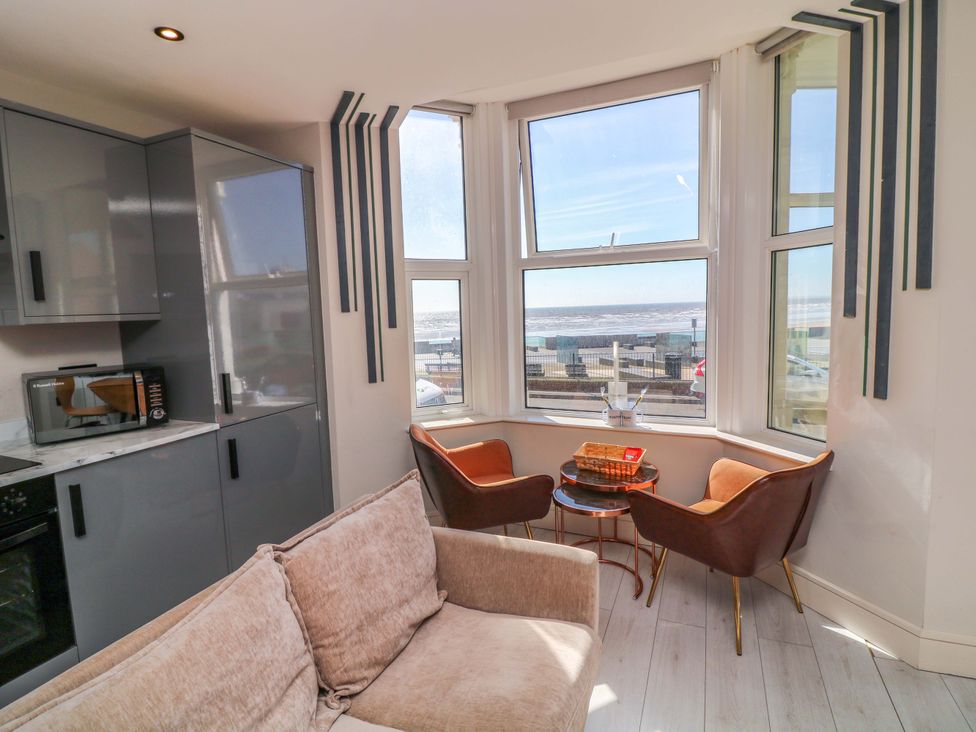 A living room with a kitchen area featuring a microwave and oven at Apt 4 @ Hunter's Quay, Bridlington