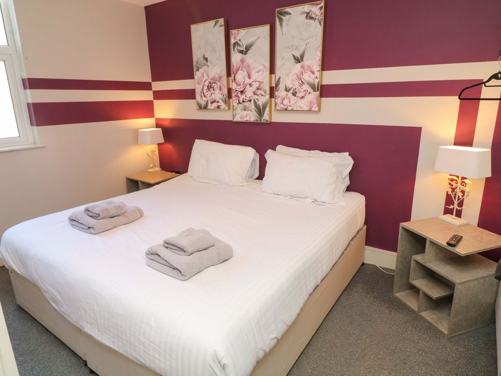 A bedroom with a bed and bedside tables at Apt 4 @ Hunter's Quay in Bridlington