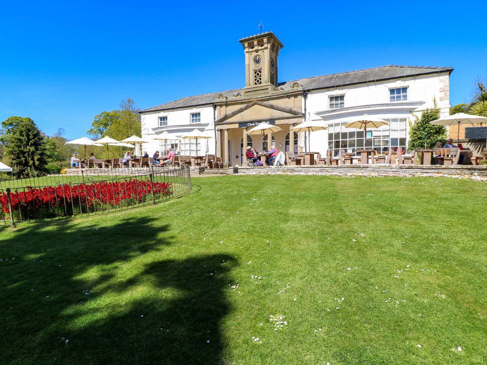 An outdoor seating area with a clock tower and flower bed at Apt 4 @ Hunter's Quay, Bridlington
