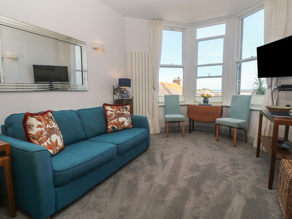 A living room with a sofa and chairs at Heron in St Ives