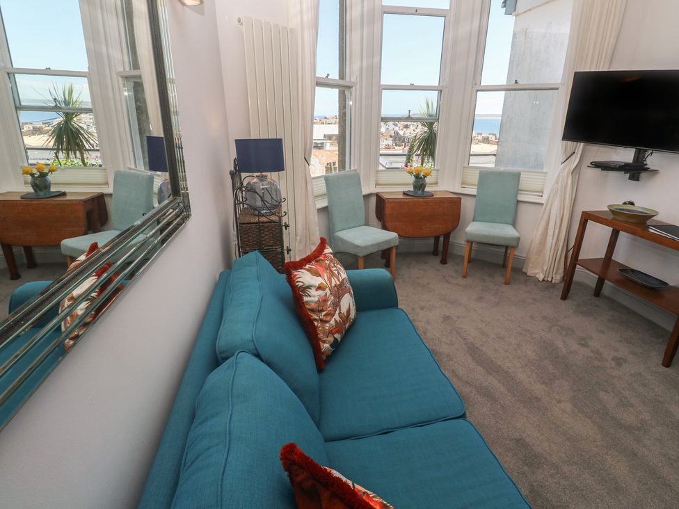 A living room with a sofa and chairs at Heron in St Ives