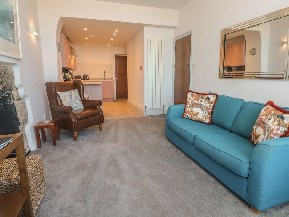A living room with a sofa and armchair at Heron in St Ives