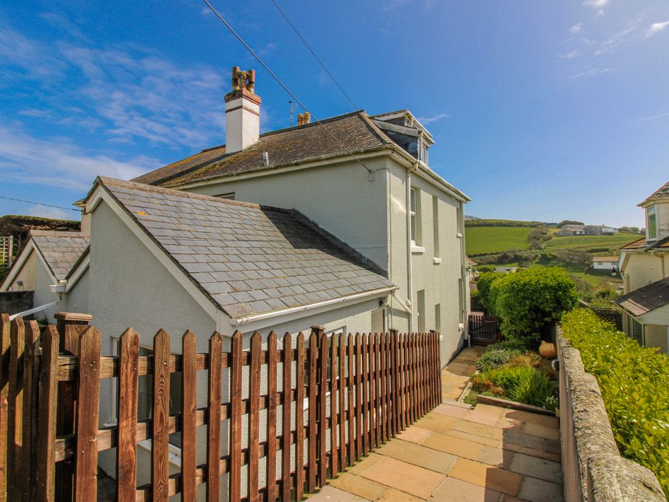 A side view of a house with a pathway and garden at Eddystone in Hope Cove
