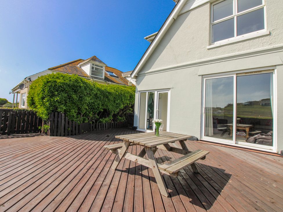 A deck area with wooden furniture at Eddystone in Hope Cove
