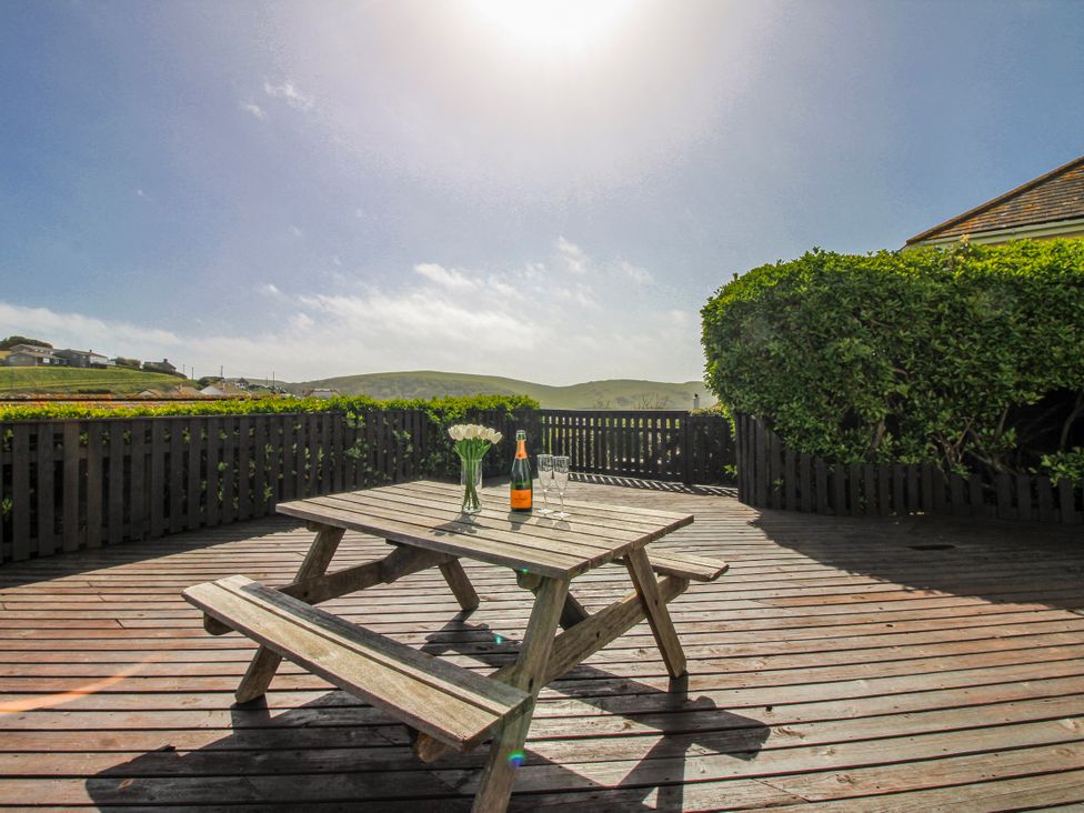 A table with drinks and flowers on a deck at Eddystone in Hope Cove