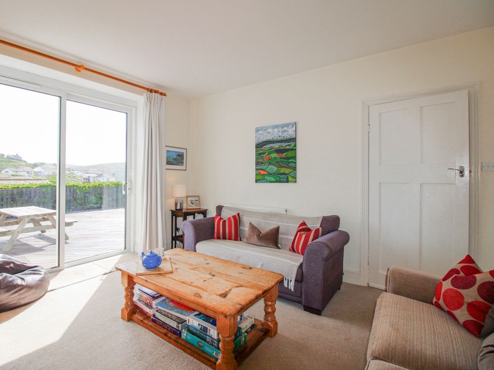 A living room with a sliding glass door and a coffee table at Eddystone in Hope Cove