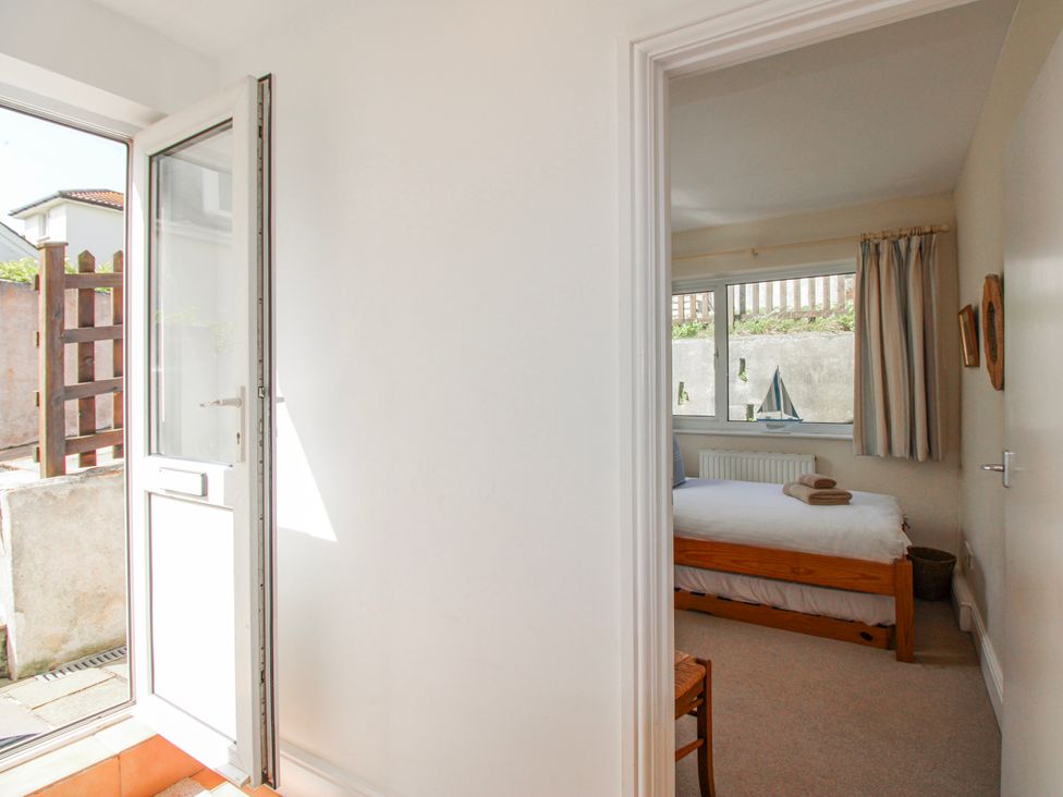 A bedroom with a bed and window at Eddystone in Hope Cove
