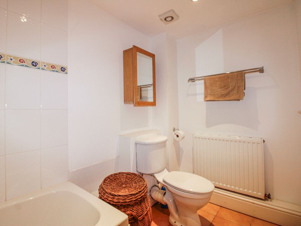 A bathroom with a sink, toilet, and mirror at Eddystone in Hope Cove