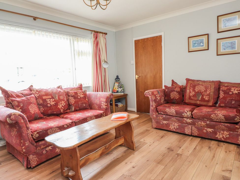 A living room with sofas and a coffee table at Bro Mebyd in Criccieth
