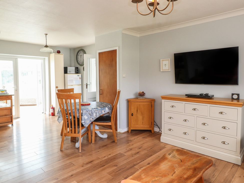 A dining room with a table and chairs at Bro Mebyd in Criccieth