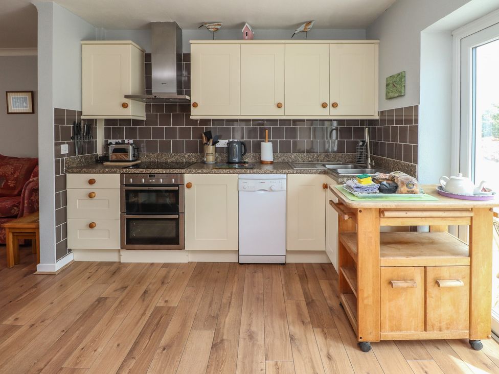 A kitchen with cabinets and appliances at Bro Mebyd in Criccieth