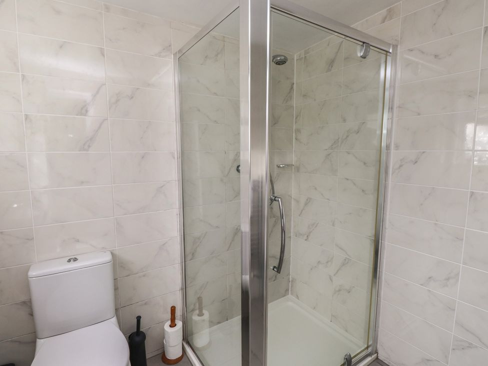 A bathroom with a shower and toilet at Bro Mebyd Criccieth