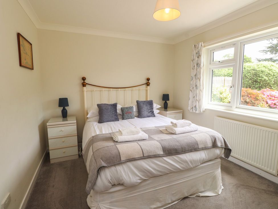 A bedroom with a bed and nightstands at Bro Mebyd in Criccieth