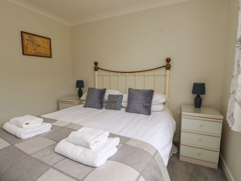 A bedroom with a bed and bedside tables at Bro Mebyd in Criccieth