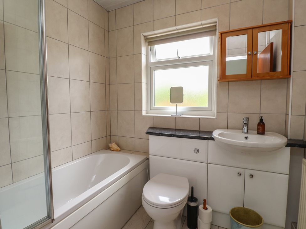 A bathroom with a bathtub, toilet, and sink at Bro Mebyd in Criccieth