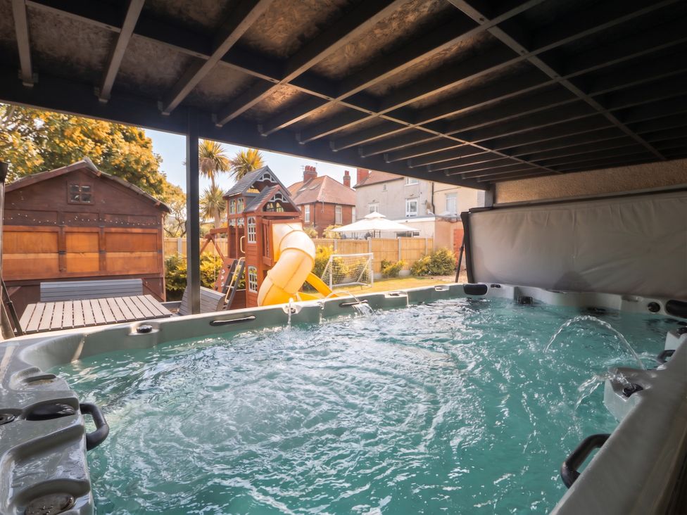 A hot tub with a slide and playhouse in the backyard at Cabin Hill in Rhos-On-Sea