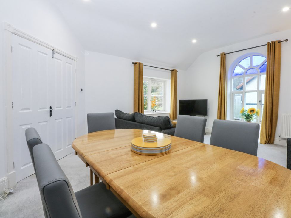 A dining room with a table and chairs at Capel Y Ffynnon near Llandudno Junction