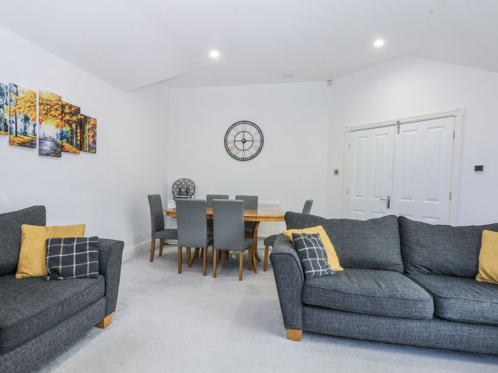 A living room with a dining area and wall art at Capel Y Ffynnon near Llandudno Junction