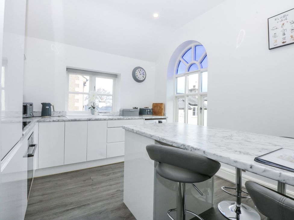 A kitchen with a marble island and bar stools at Capel Y Ffynnon in Bryan Pardew near Llandudno Junction