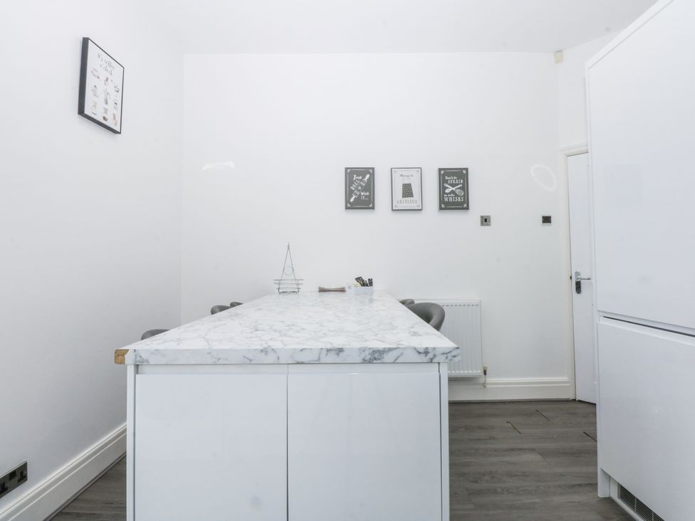 A kitchen with a marble countertop and wall art at Capel Y Ffynnon near Llandudno Junction