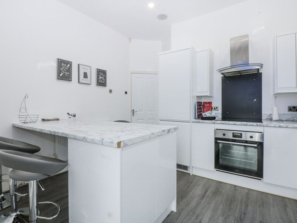 A kitchen with a marble island and bar stools at Capel Y Ffynnon near Llandudno Junction