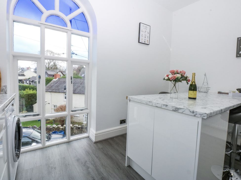 A kitchen with a window and washing machine at Capel Y Ffynnon near Llandudno Junction