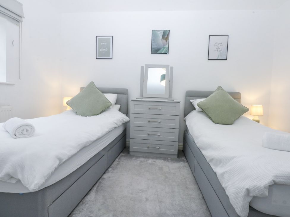 A bedroom with two beds and a dresser at Capel Y Ffynnon near Llandudno Junction