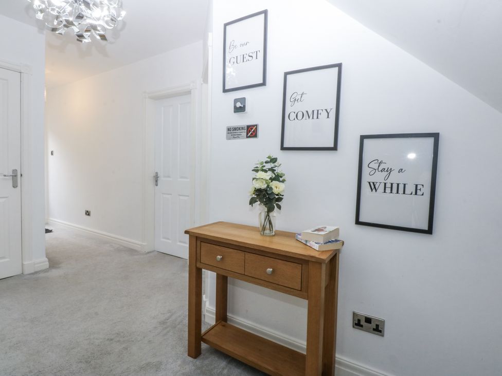 A hallway with a console table and wall art at Capel Y Ffynnon near Llandudno Junction