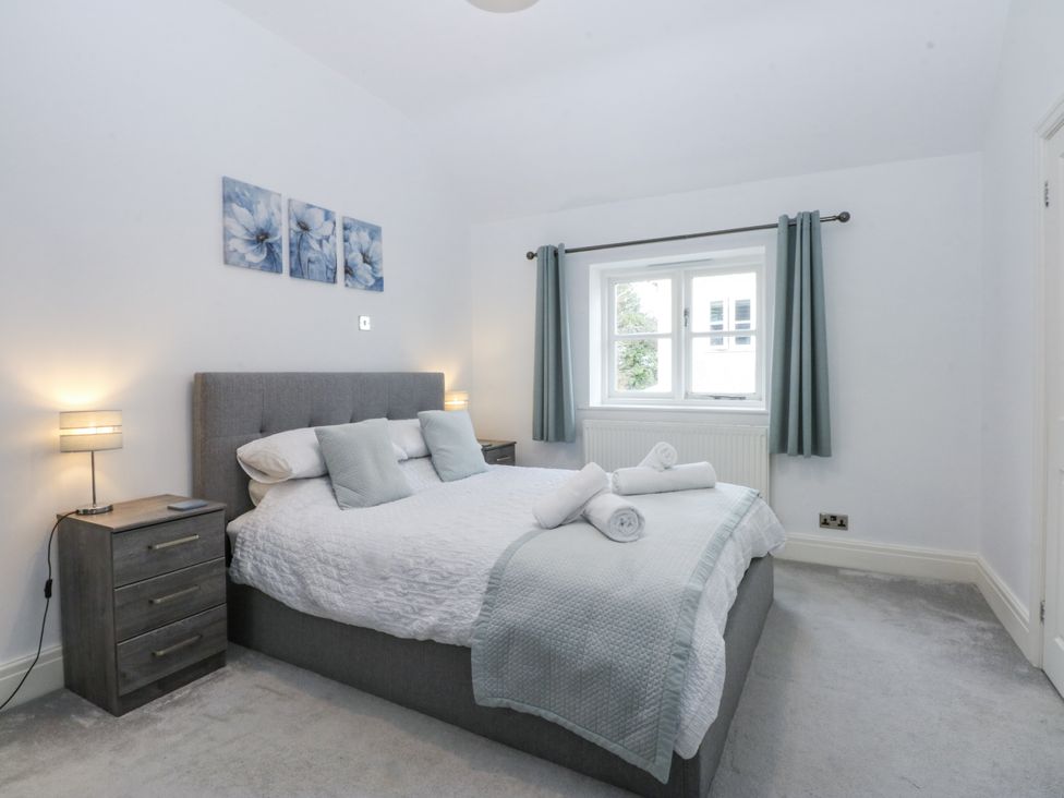A bedroom with a bed and curtains at Capel Y Ffynnon near Llandudno Junction
