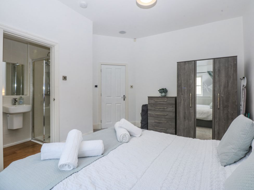 A bedroom with a bed and wardrobe at Capel Y Ffynnon near Llandudno Junction