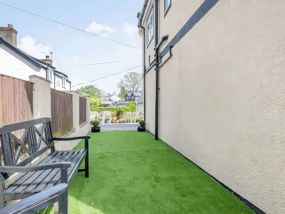 A garden area with a bench and green grass at Capel Y Ffynnon, Bryn Pydew near Llandudno Junction