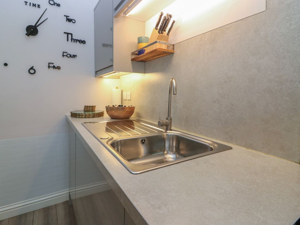 A kitchen with a sink and knife block at 2 Abbey Row in Kelso