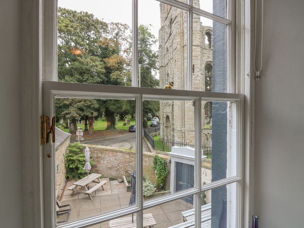 A view of trees and a historic building from a window at 2 Abbey Row in Kelso